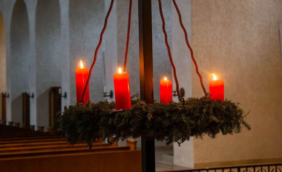 Adventskranz, bei dem vier Kerzen angezündet sind.