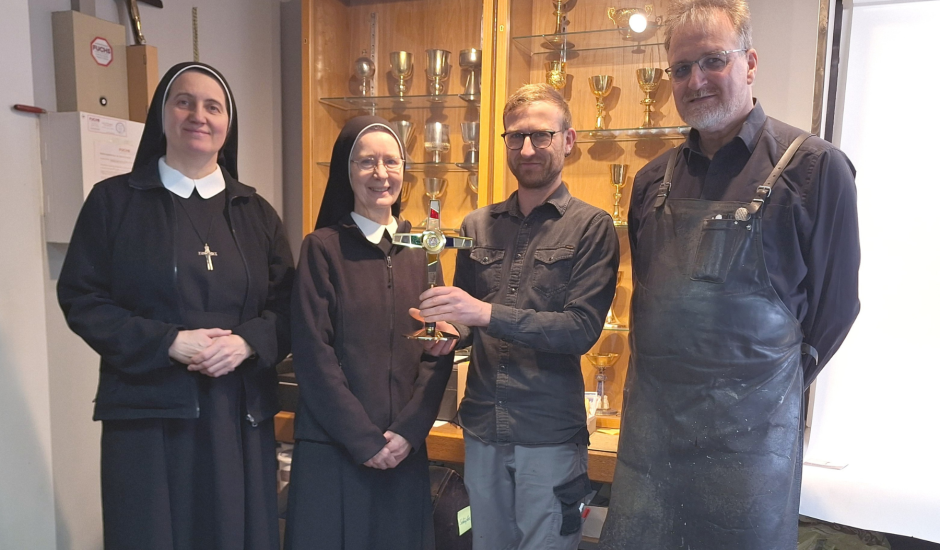 Zwei Ordensschwestern und zwei Mitarbeiter bei der Übergabe des Reliquiars