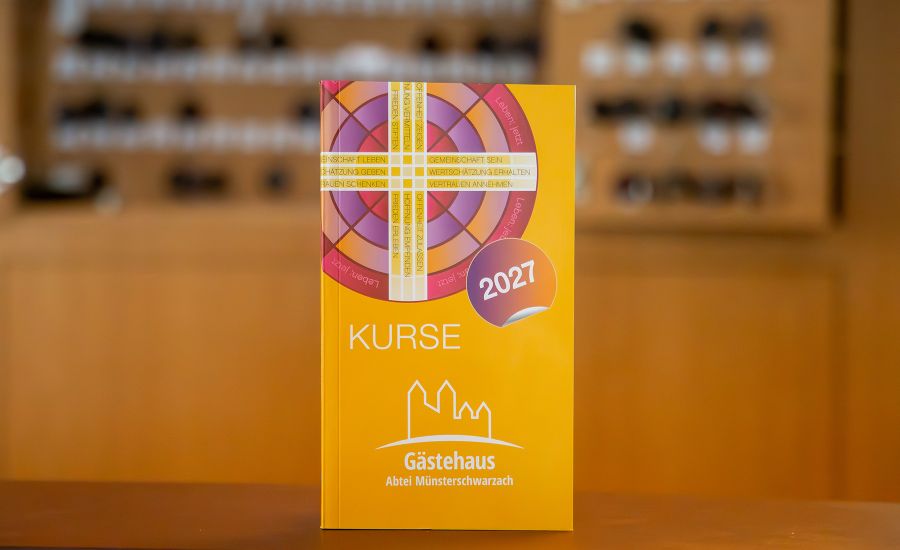 Oranges Buch, im Hintergrund sieht man verschwommen einen Schlüsselkasten