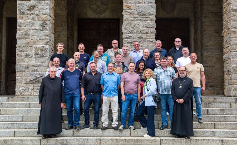 Gruppenfoto der ehemaligen Auszubildenden auf der Treppe der Abteikirche