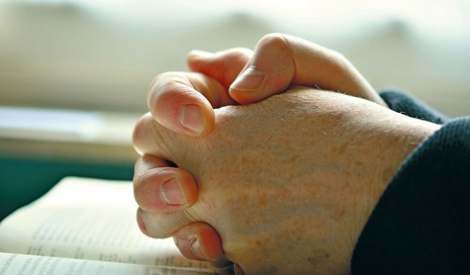 Betende Hände auf einer Bibel