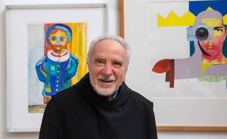 Mönch vor zwei bunten Bildern