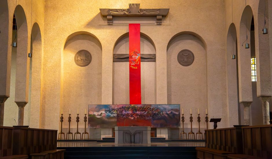 Rote Stoffbahn bedeckt Kreuz im Altarraum der Kirche