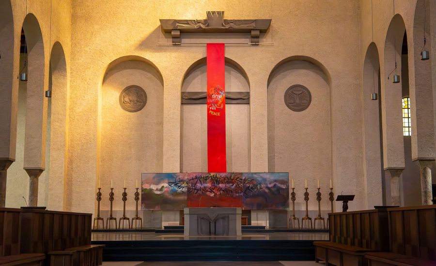 Rote Stoffbahn bedeckt Kreuz im Altarraum der Kirche