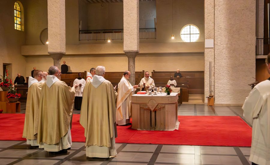 Gruppe von Priestern in weißen Gewändern vor einem Tischaltar