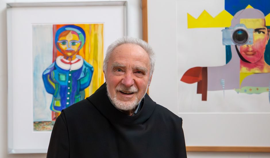 Mönch vor zwei bunten Bildern